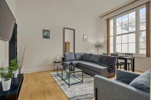 a living room with a couch and a table at Cosy 2BR Retreat near Paddington Station in London