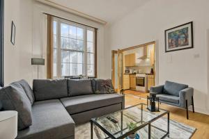 a living room with a couch and a table at Cosy 2BR Retreat near Paddington Station in London