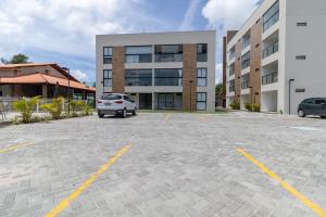 ein Auto, das auf einem Parkplatz vor einem Gebäude geparkt ist in der Unterkunft Oásis Tropical no San Martin - Destino BSM 303 A in Barra de São Miguel