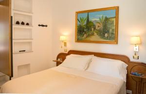 a bedroom with a bed and a painting on the wall at Villa Schuler Taormina GARDEN SUITE IN SELF-CATERING in Taormina