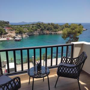 a balcony with a table and chairs and the ocean at Pansion Nikos in Patitiri