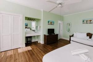 a bedroom with a bed and a bathroom with a sink at King Suite at Curry Mansion with Heated Pool by Brightwild! in Key West