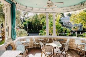 a restaurant with tables and chairs and a patio at King Suite at Curry Mansion with Heated Pool by Brightwild! in Key West