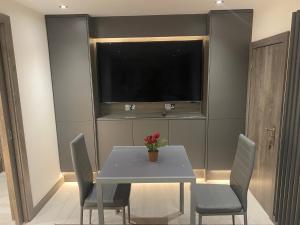 comedor con mesa con sillas y TV en Modern studio in natural surroundings, en Four Oaks