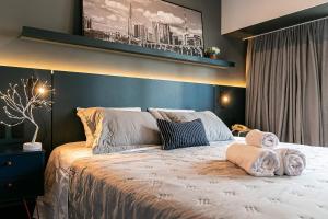 a bedroom with a large bed with towels on it at Flat 1501 WCT Berrini Brooklin in São Paulo