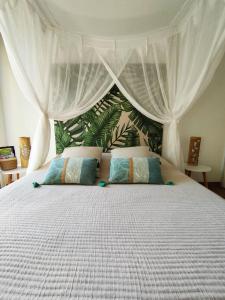 1 dormitorio con 1 cama blanca con dosel en Ti Grounouy en Le Diamant