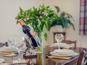 - une table avec une bouteille de vin et un vase avec des fleurs dans l'établissement 2 Bed in Bournemouth 78541, à Ferndown