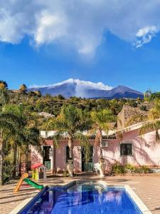 a house with a swimming pool with mountains in the background at VILLA PANORAMICA DELL'ETNA in SantʼAlfio