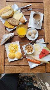 a table topped with plates of food and a cup of coffee at Tapindaré Hotel in Alto Paraíso de Goiás