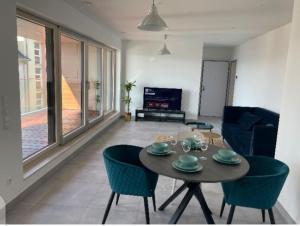 een woonkamer met een tafel en stoelen en een televisie bij One bedroom apartment in center w. Terrace&Parking in Luxemburg