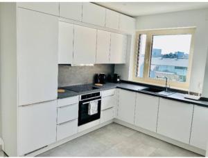 een witte keuken met witte kasten en een raam bij One bedroom apartment in center w. Terrace&Parking in Luxemburg