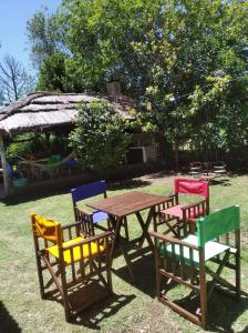 un gruppo di sedie attorno a un tavolo di legno con un tavolo e sedie di Casa quinta La Panambí a Campana