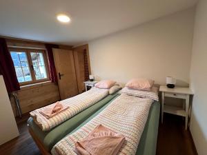 two beds sitting next to each other in a room at One Bedroom with mountain and garden view ground floor of Chalet Solaria in Zweisimmen
