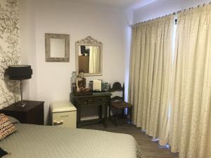 um quarto com uma cama e uma secretária com um espelho em Habitación deluxe con baño privado en Atalaya Apartagolf, Estepona em Estepona