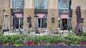 a patio with tables and umbrellas in front of a building at Downtown Oasis, Burj Khalifa Views, Luxury Amenities in Dubai