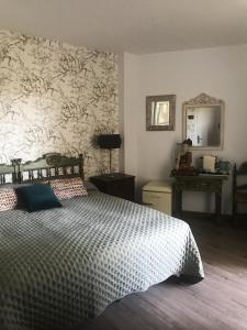 um quarto com uma cama e uma parede com papel de parede em Habitación deluxe con baño privado en Atalaya Apartagolf, Estepona em Estepona