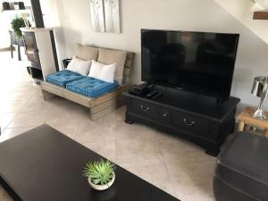 a living room with a large television and a couch at MAISON NOTRE DAME DE MONTS in Notre-Dame-de-Monts