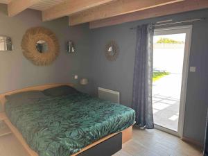 a bedroom with a bed with a green comforter at MAISON NOTRE DAME DE MONTS in Notre-Dame-de-Monts +16 photos