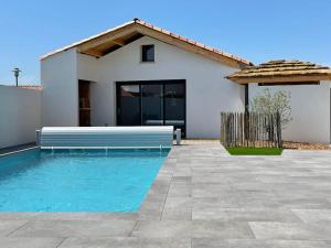 a house with a swimming pool in front of a house at MAISON NOTRE DAME DE MONTS in Notre-Dame-de-Monts