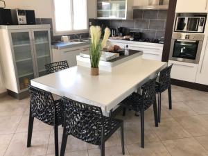 a kitchen with a large white table and chairs at MAISON NOTRE DAME DE MONTS in Notre-Dame-de-Monts