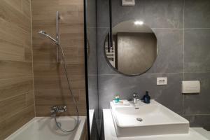 a bathroom with a sink and a shower and a mirror at Apartament Storyland in Braşov +32 photos