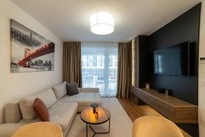 a living room with a couch and a tv at Apartament Storyland in Braşov