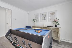 a ping pong table in a room with ahibition at Newly Refurbished 3BR House Basildon, Garden, Netflix & Trisport Table in Nevendon