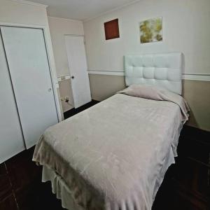 a bedroom with a large bed with a white headboard at Casa en condominio jardines del norte Antofagasta. in Antofagasta