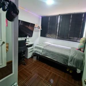 a bedroom with a bed and a desk and a window at Casa en condominio jardines del norte Antofagasta. in Antofagasta