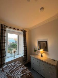 a bedroom with a window and a bed and a dresser at Newly refurbished flat - Callander in Callander