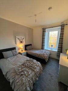 a bedroom with two beds and a window at Newly refurbished flat - Callander in Callander
