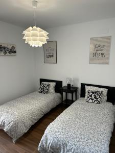 a bedroom with two beds and a chandelier at Casa Juan in Cabanes