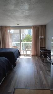 um quarto com 2 camas, uma secretária e uma janela grande em Marco Polo Beach Resort Condo with balcony em Sunny Isles Beach