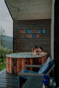 a man and a woman kissing in a hot tub at Карпатське Hygge in Slavske