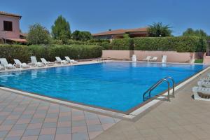 a large swimming pool with lounge chairs at Villa Aurelia - Pool, BBQ & Tennis Court - San Teodoro in San Teodoro