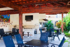 eine Terrasse mit Stühlen, einem Tisch und einem TV in der Unterkunft Arrecifes 18 in Coco