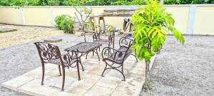 een groep stoelen en een tafel op een patio bij Kapowlito Real Estate Casa #3+4 Mon Plaisirweg in Paramaribo