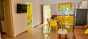 een keuken en een woonkamer met een tafel en stoelen bij Kapowlito Real Estate Casa #3+4 Mon Plaisirweg in Paramaribo