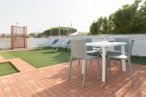 - une table et des chaises blanches sur la terrasse dans l'établissement Hotel Hawaii, à Riccione