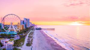 a view of the beach and a ferris wheel at sunset at Holiday Inn Club Vacations Myrtle Beach Oceanfront in Myrtle Beach