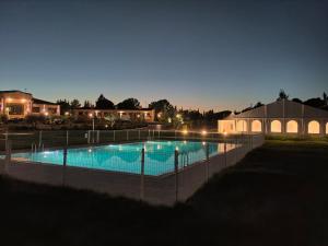 una gran piscina por la noche con luces en Finca Alarcos en Valverde
