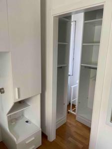a white closet with white shelves and a window at Villetta familiare a Potenza Picena in Potenza Picena