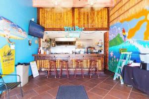 a restaurant with a bar with stools in a room at NEW Oceanside Inn 603 King Bed Ocean Views in Daytona Beach