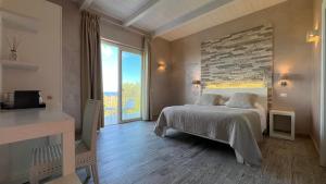 a bedroom with a bed and a large window at Borgo di Santa Barbara in Santa Domenica