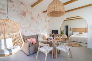 una sala de estar con un sofá, una mesa y sillas en Sirma Beach House, en Kimolos