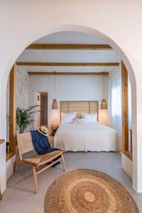 Un dormitorio con una cama grande y una silla. en Sirma Beach House, en Kimolos