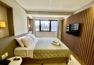 um quarto de hotel com uma cama e uma janela em GOLDFLAT - Manaíra by PenareiaTurBr em João Pessoa