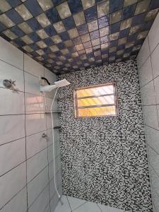 a bathroom with a tiled shower with a window at Hostel My House quartos perto do aeroporto de Guarulhos in Guarulhos