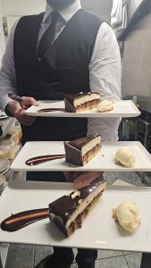 um chef com duas bandejas de sobremesas em pratos em 53 Luxury Rooms em Maynooth