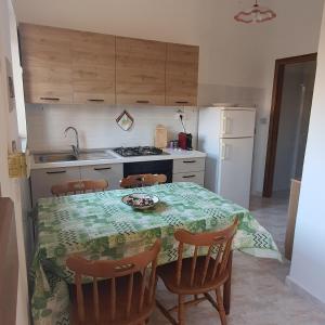 a kitchen with a table and chairs and a kitchen with a stove at Casa ponente...a due passi dal mare in Porto Alabe